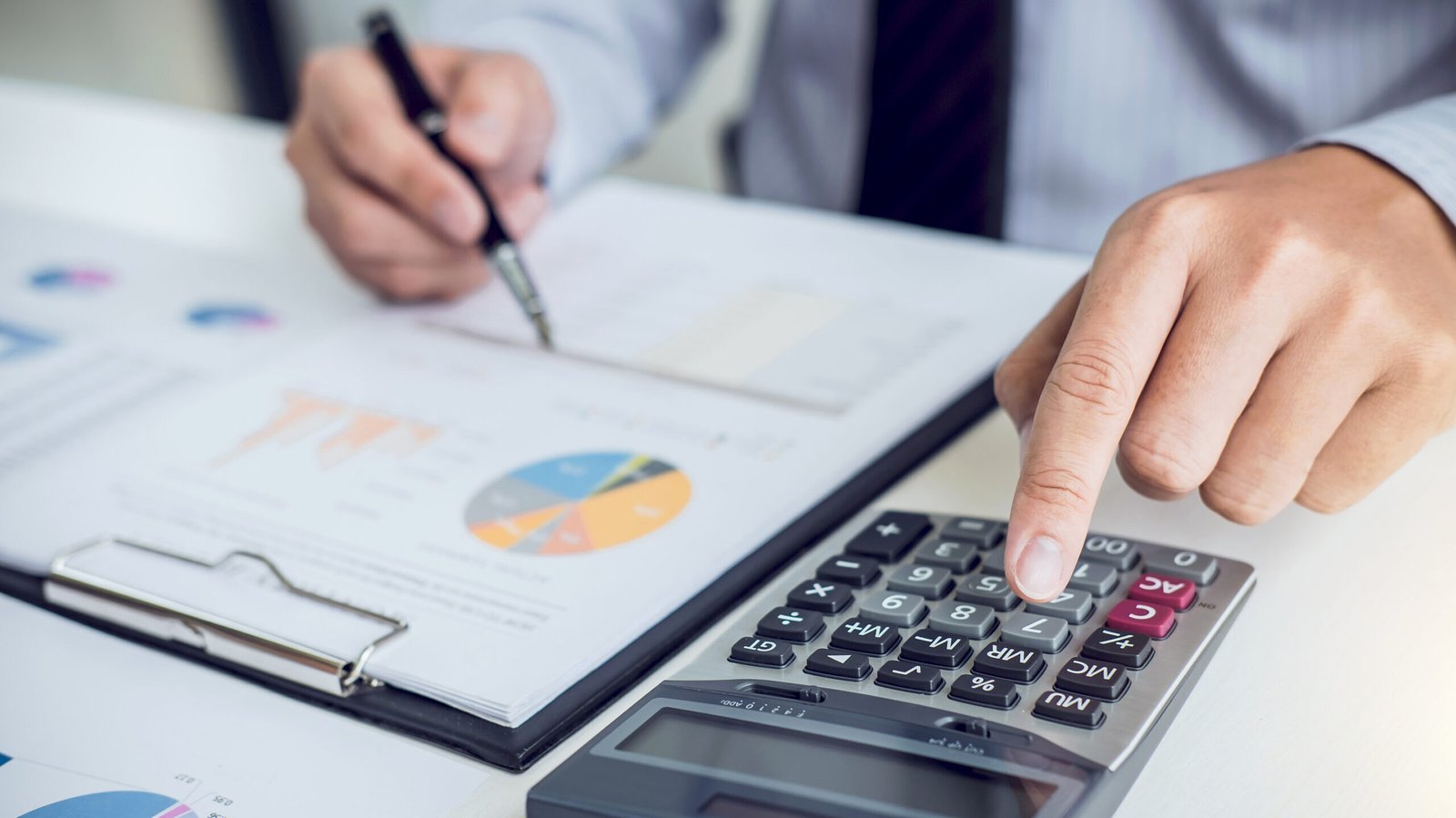 Business man or accountant working Financial investment on calculator with calculate Analyze business and market growth on financial document data graph and writing ,Accounting,Economic,commercial.